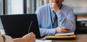 Man sitting at desk in front of laptop.